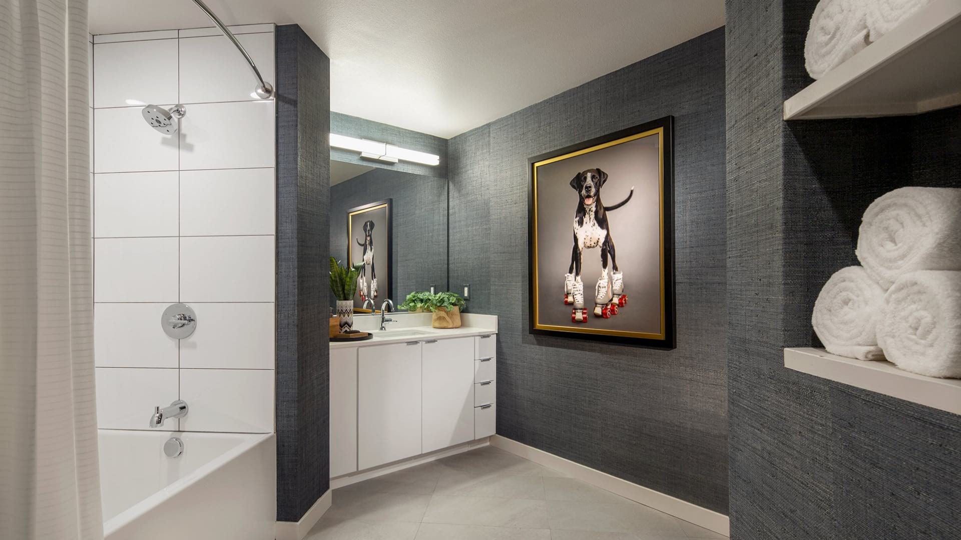 Modern bathroom at Neptune Marina with shower and bath, sink, bright lighting, and art on the wall