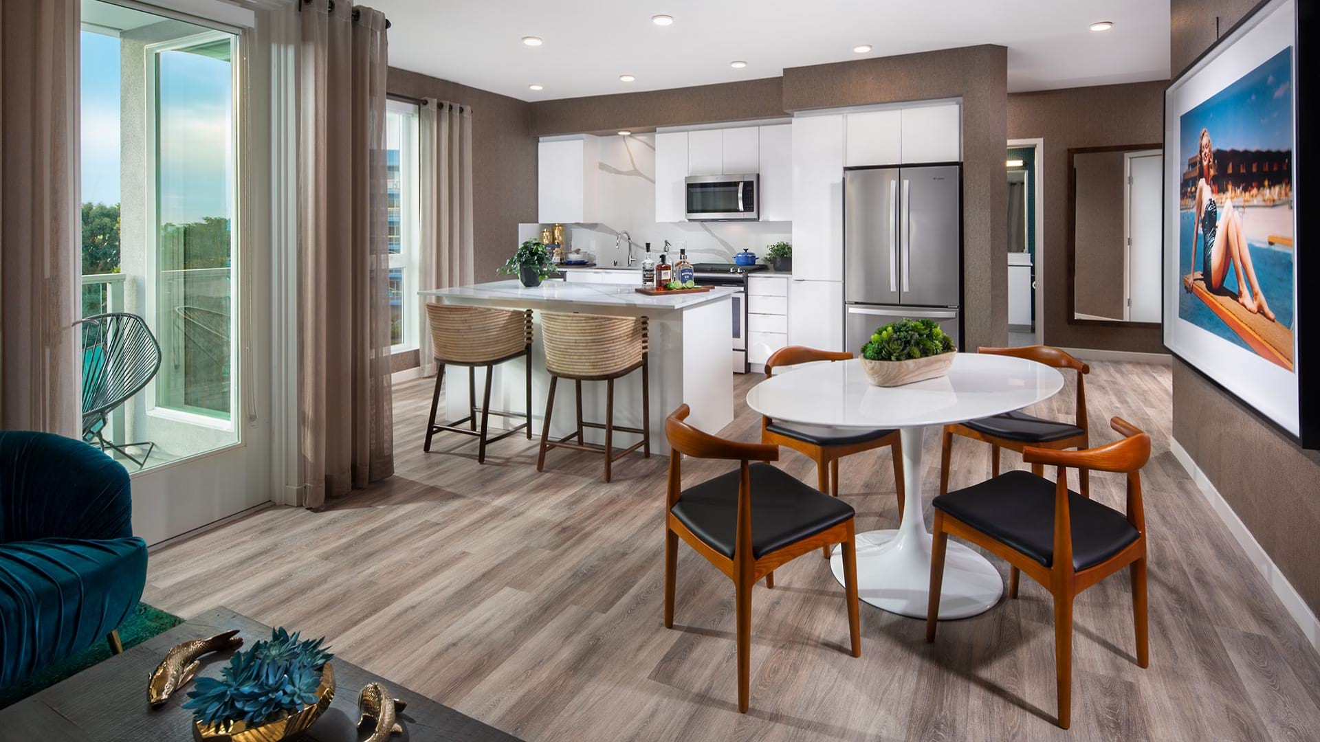 Open concept kitchen at Neptune Marina with a dining table, kitchen island, stainless steel appliances and floor to ceiling windows