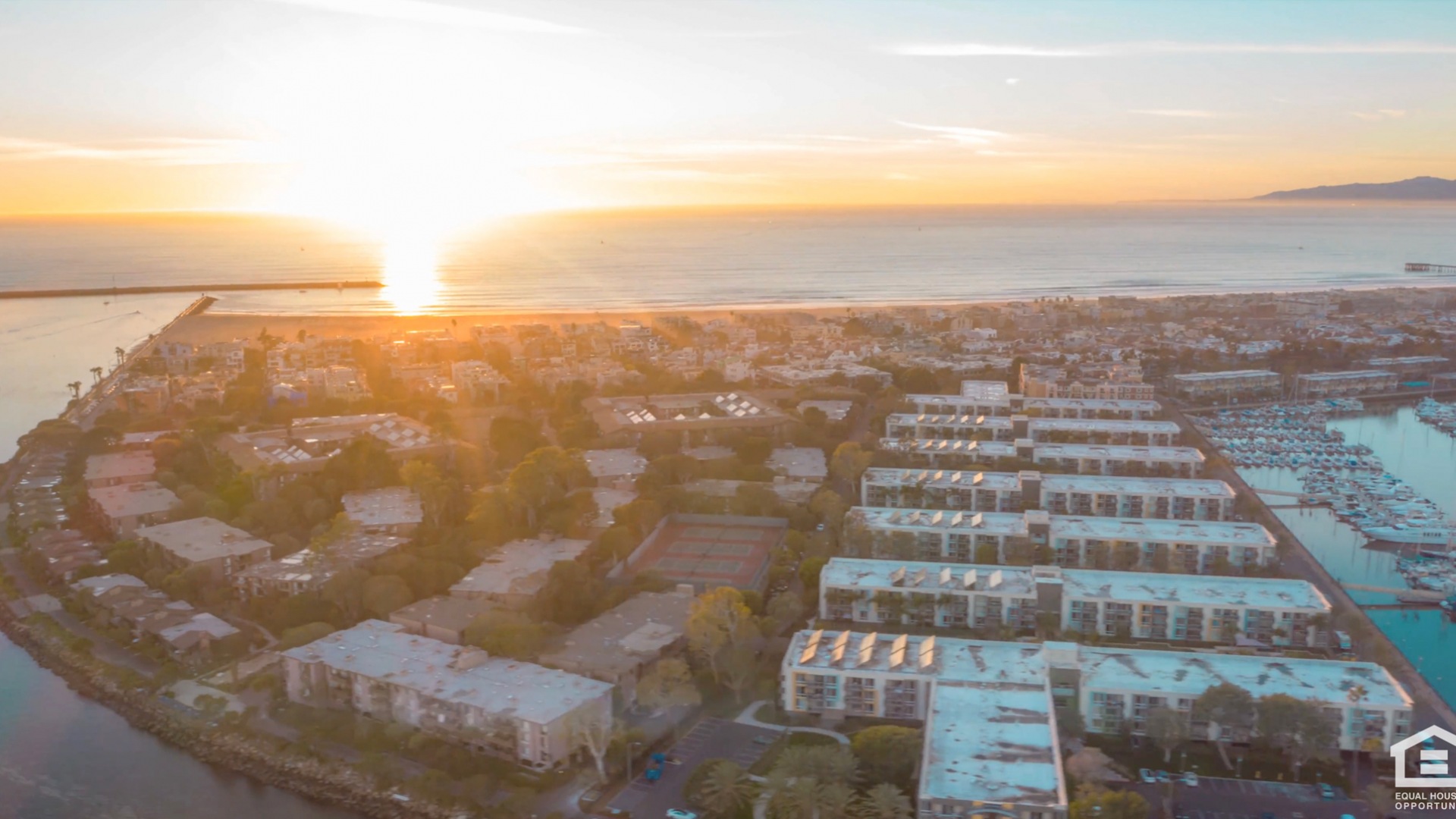 Aerial view of Neptune Marina apartments in Marina del Rey, California near the ocean at sunset.